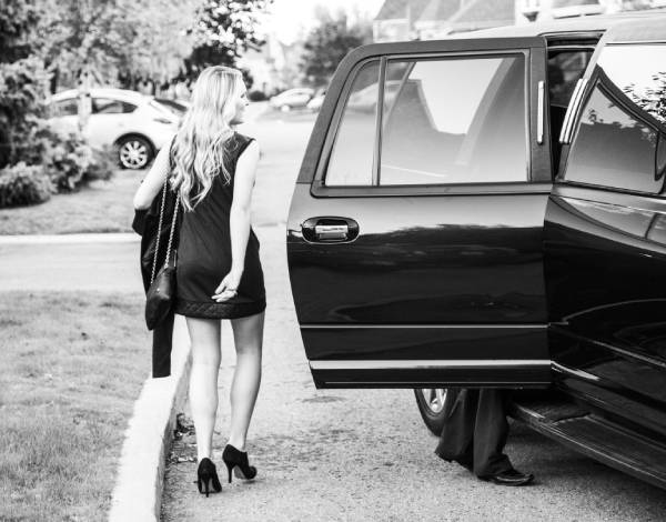 Kvinna i en förort i Stockholm på väg in i en svart limousine, på väg till ett event.